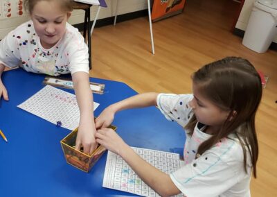 Students use crayons to complete a math worksheet