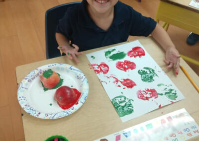 young student learning by using apple stamps